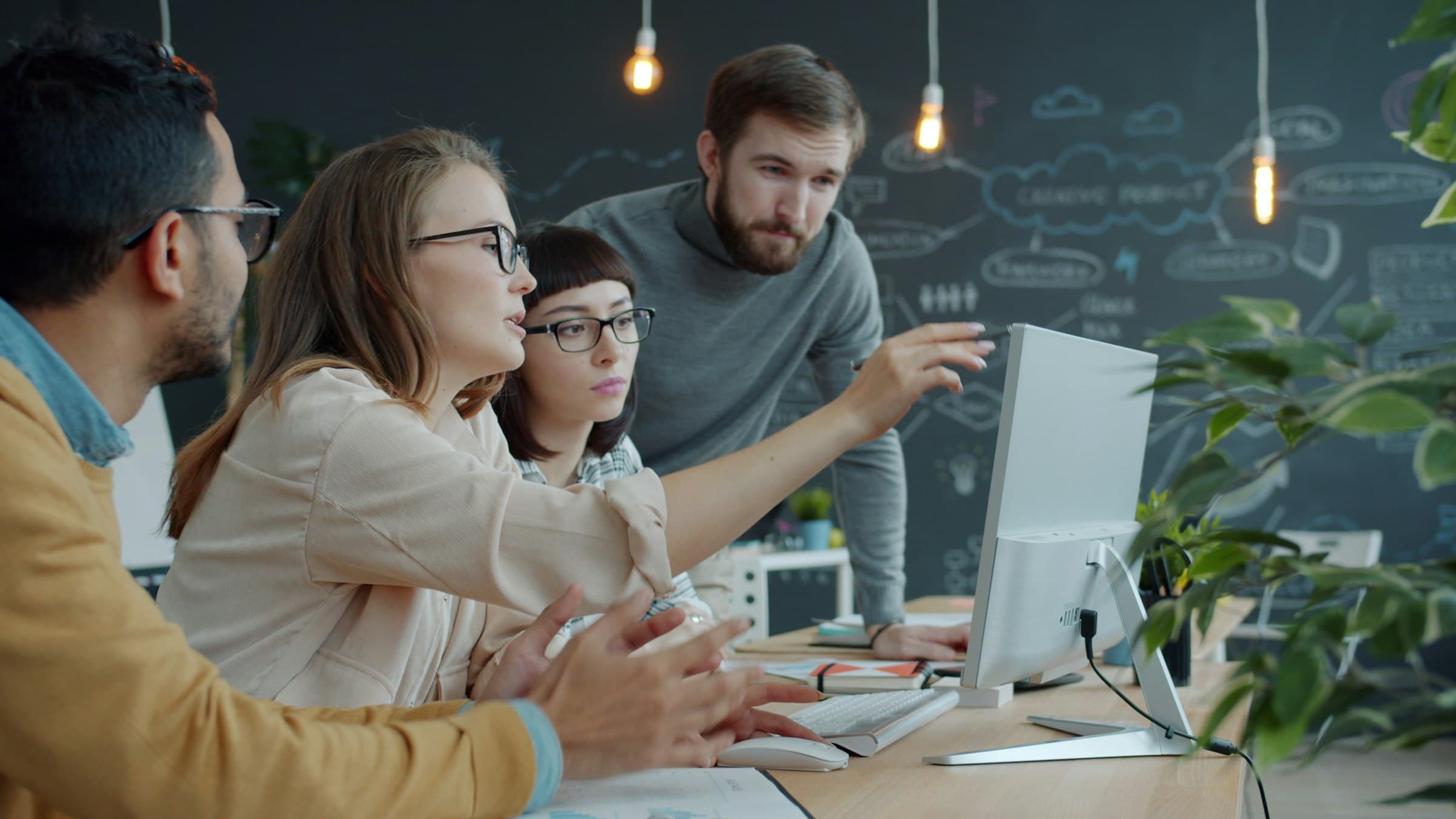 Colleagues reviewing information together on a computer screen